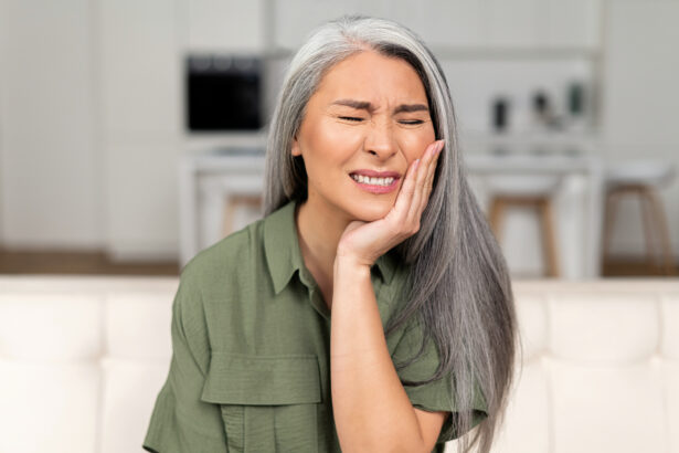 Troubled mature 50s woman with gray-hair feels strong toothache, holding cheek and suffering from strong dental pain sitting on sofa, middle-aged female undergoing tooth pain, enamel sensitivity "Anxious about my upcoming root canal"