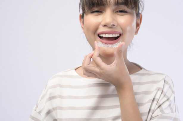 A young smiling woman holding invisalign braces over white background studio. Invisalign Braces Cost.
